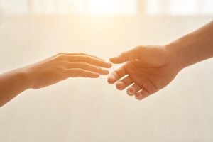 one hand moving towards another to illustrate support 