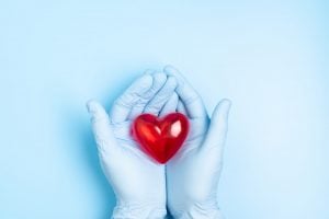 blue gloves holding a heart