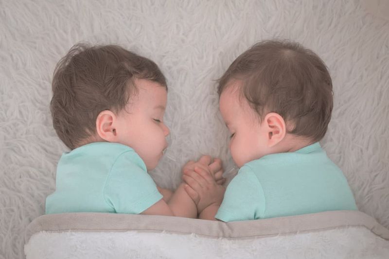 Twin babies facing each other